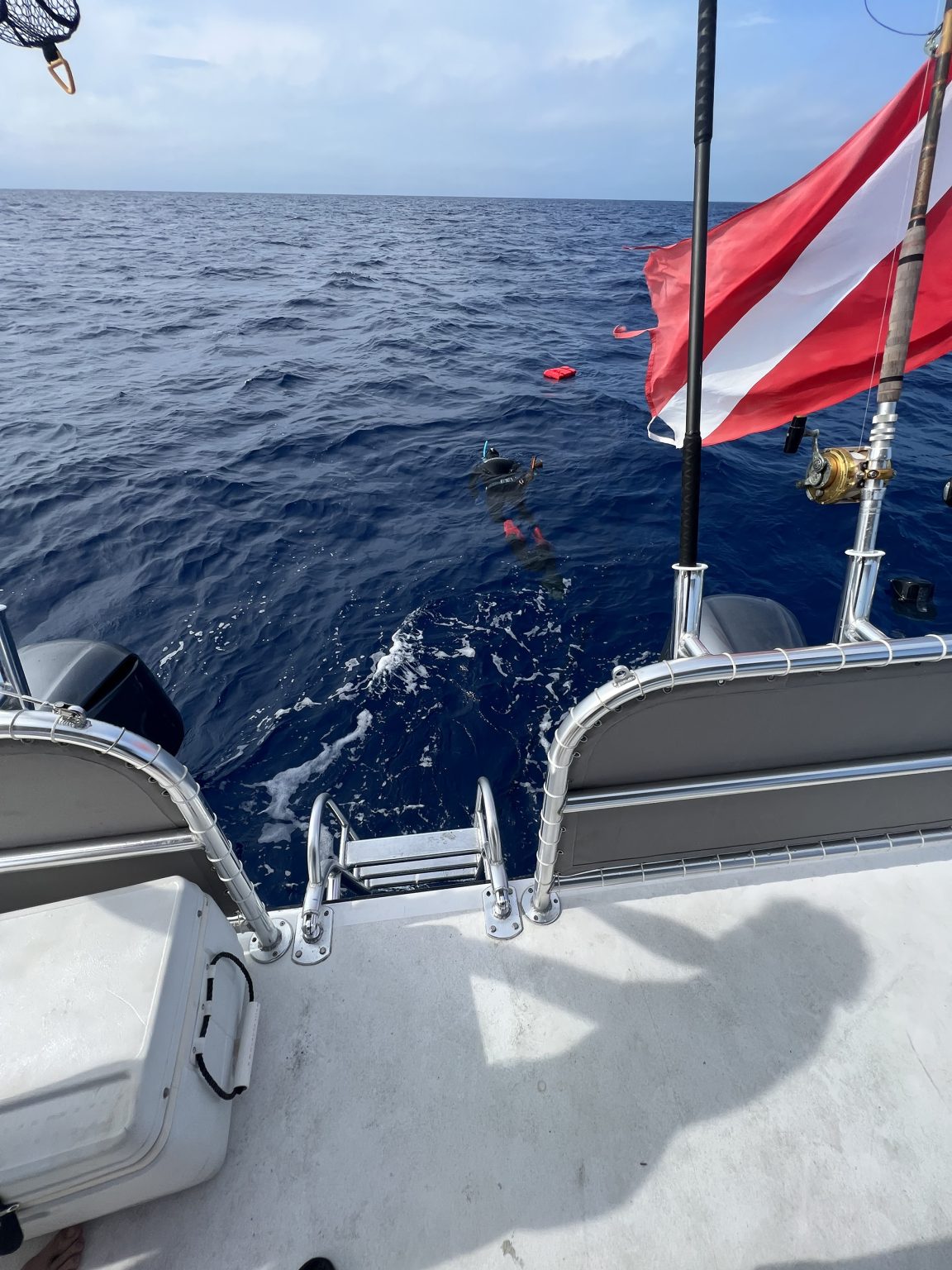 View from a boat showing the ocean, a diver with gear underwater