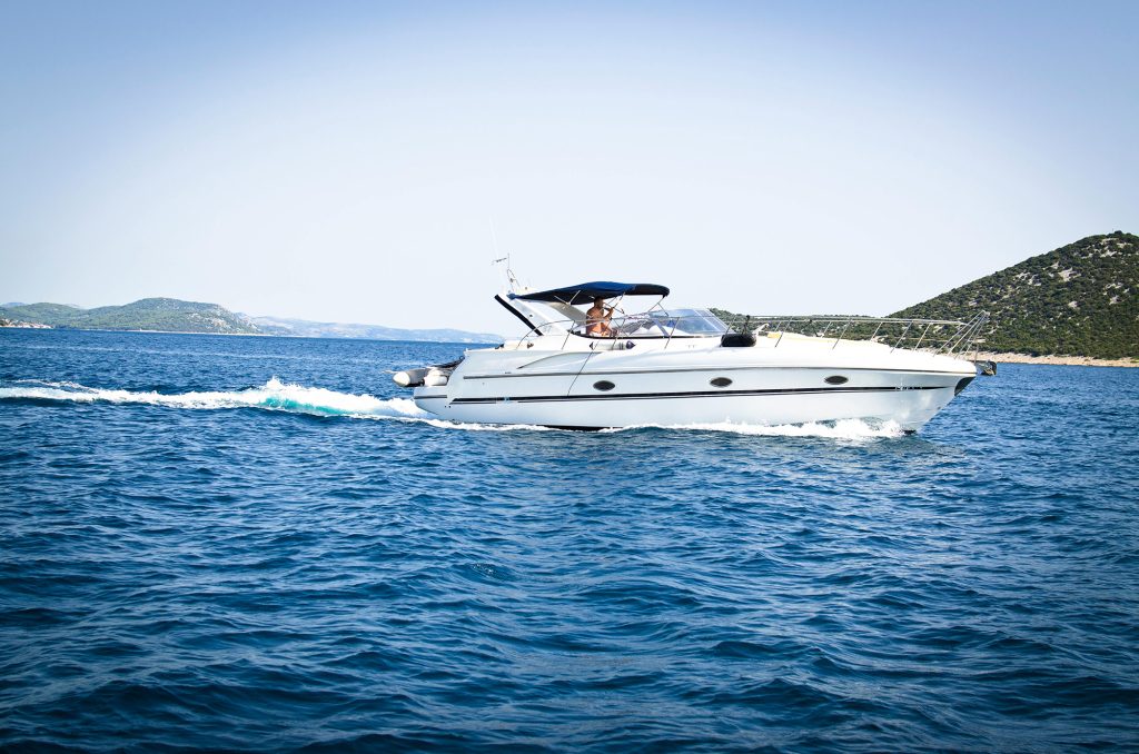 A small boat gently floating on calm water under a clear blue sky.