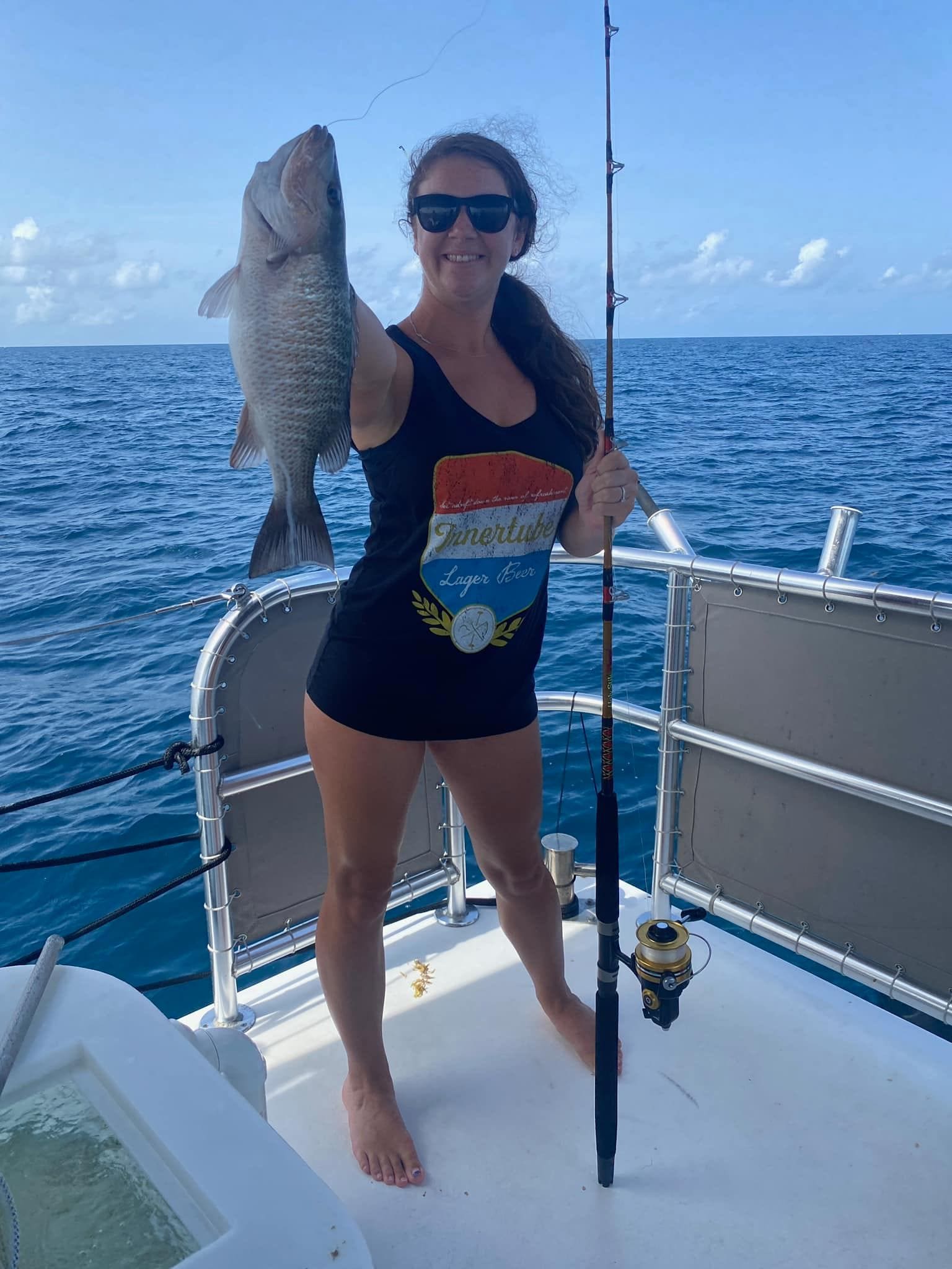 Woman showcasing her big catch aboard Custom Cat Charters fishing charter